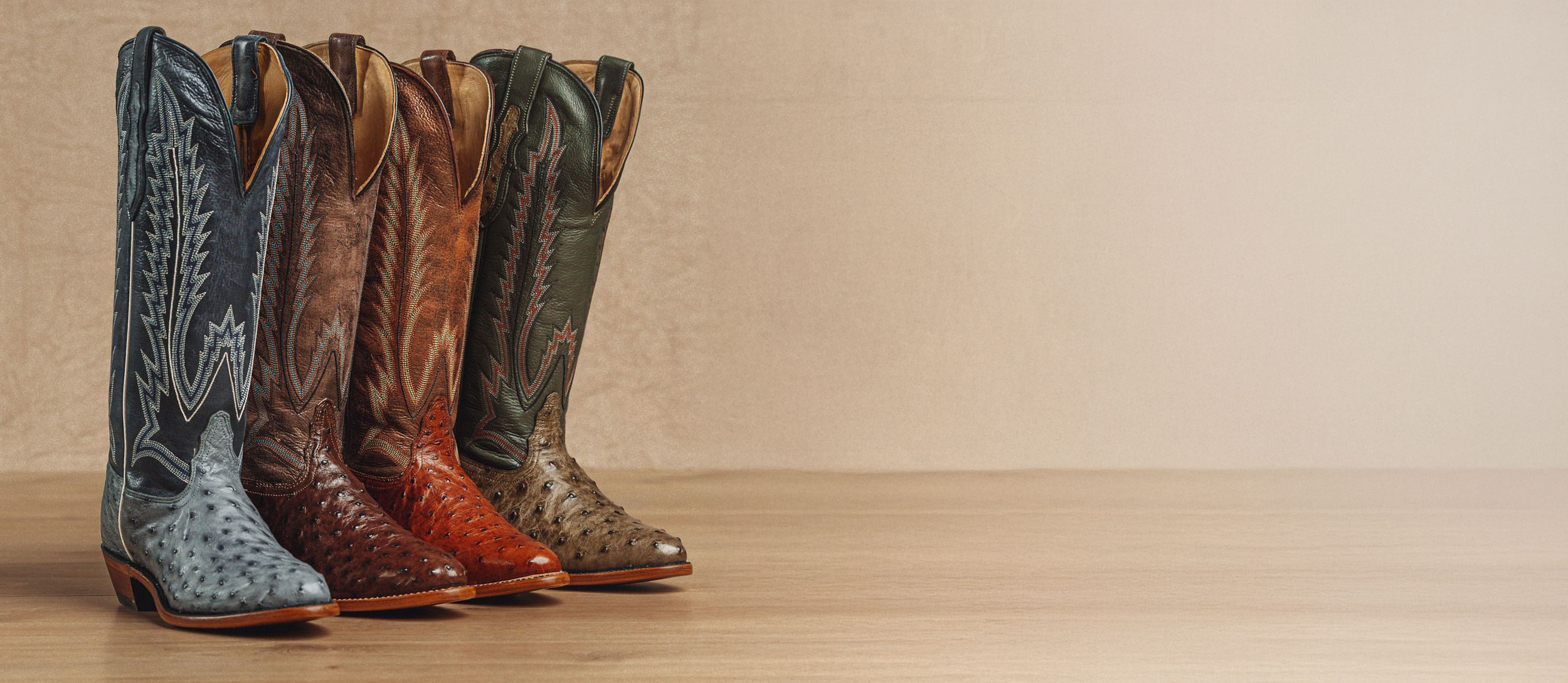 A lineup of the Quintana Full Quill Ostrich western boots in blue, dark brown, light brown and green.
